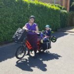 Hilary on a Tern cargo bike, carrying a child and a lot of luggage
