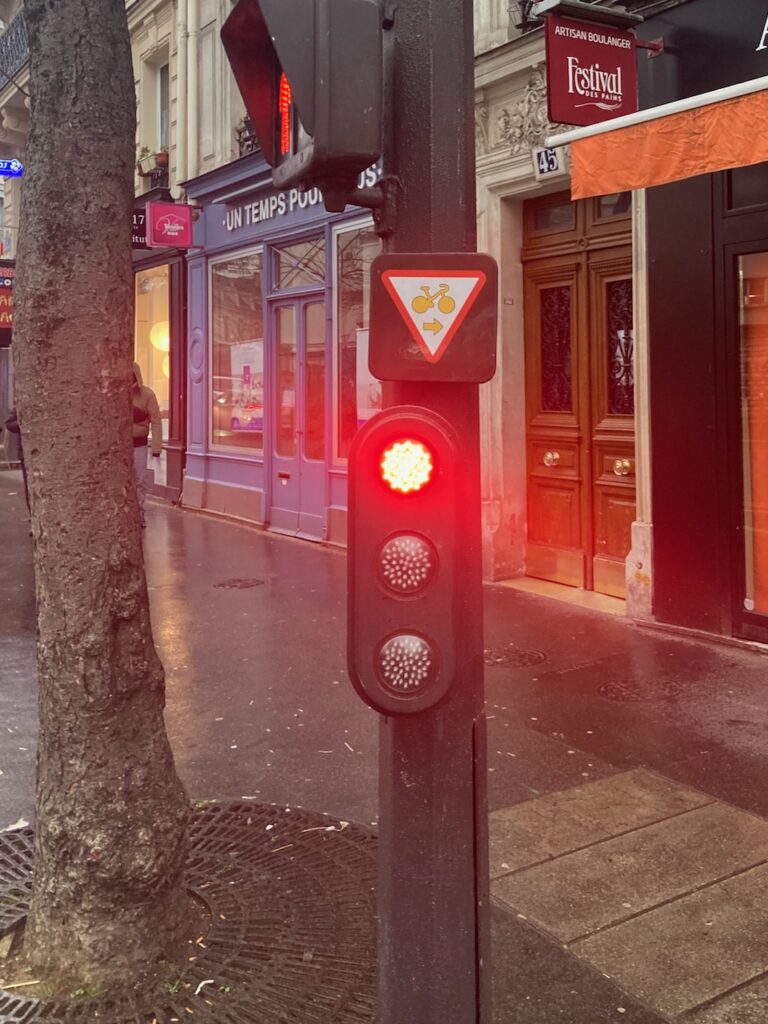 Traffic light with the triangular sign to jump the red light in Paris